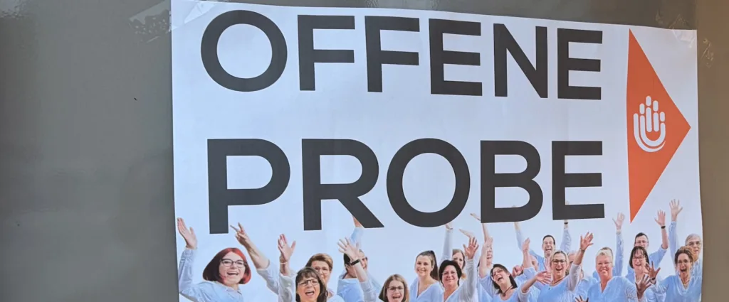 Plakat zur offenen Chorprobe des JungerChor TakeFour in Ludwigshafen. Abgebildet ist der Chor in weißen Hemden mit der Aufschrift Offene Probe – Herzlich Willkommen. Das Bild lädt alle Interessierten ein, bei der Chorprobe mitzusingen oder zuzuhören.